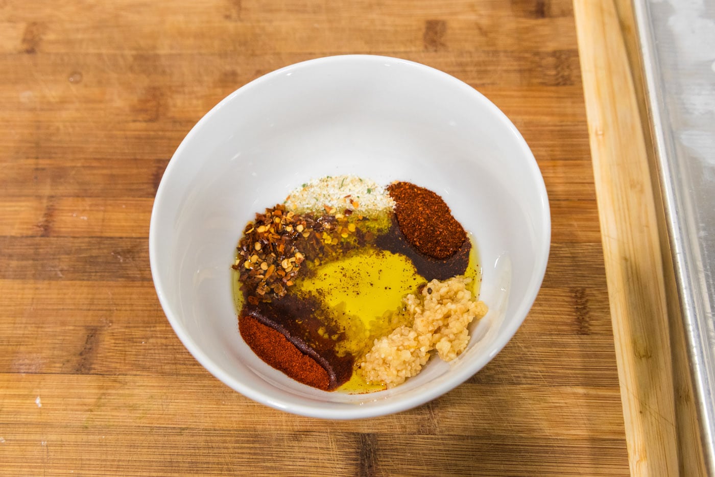 red pepper flakes, oil, garlic, cayenne, and chili powder in a bowl