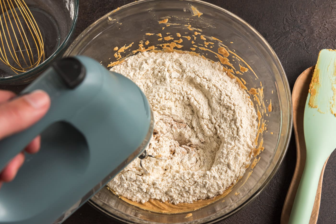 adding dry ingredients to wet ingredients for cookie dough