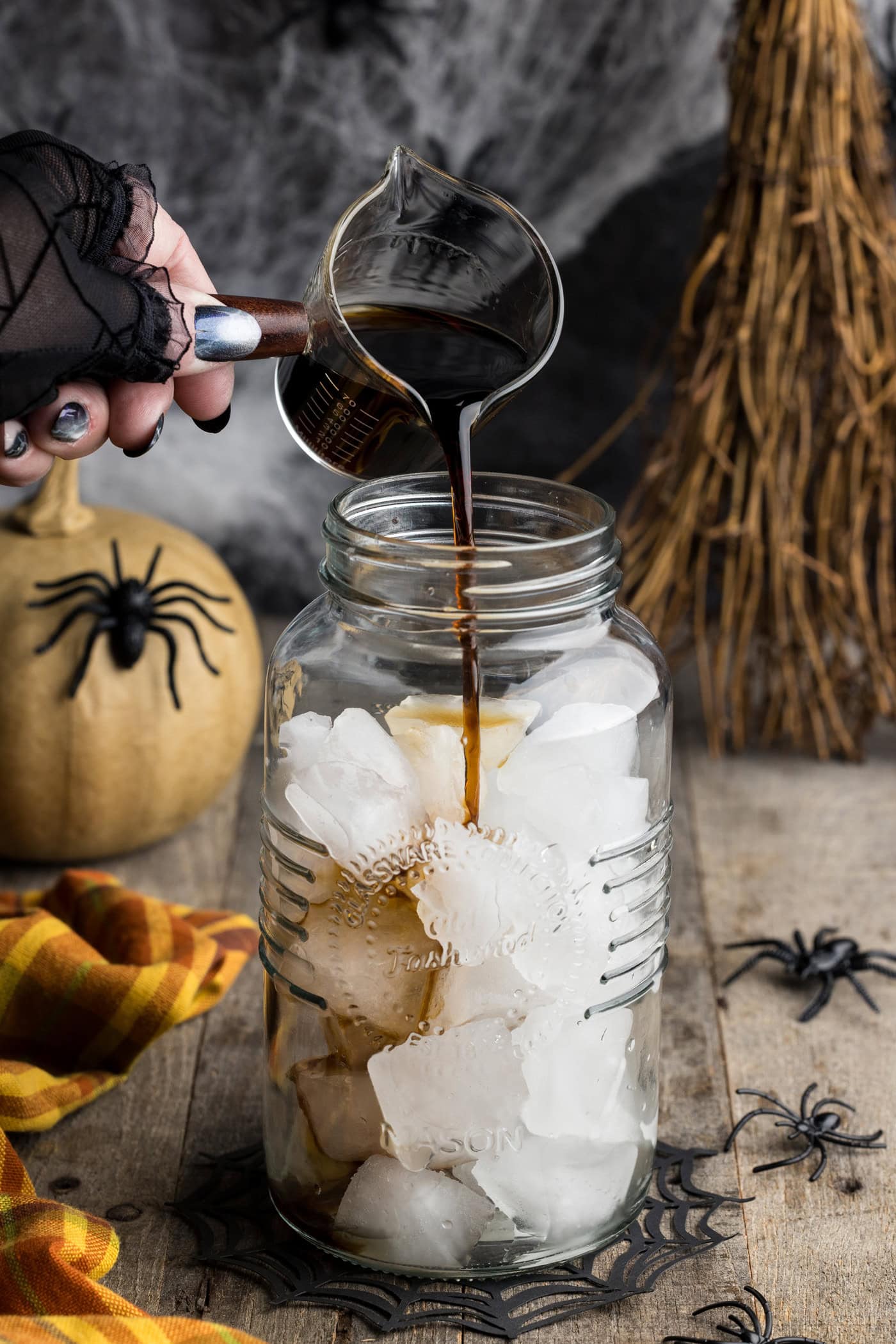 Pouring Kahlua into a cocktail shaker with ice
