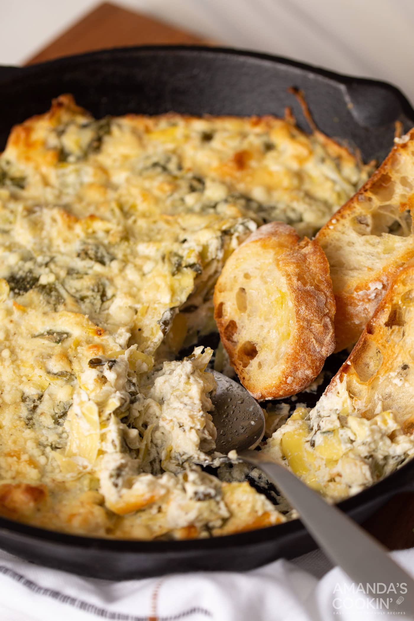 pan of Spinach Artichoke Dip with a spoon in it