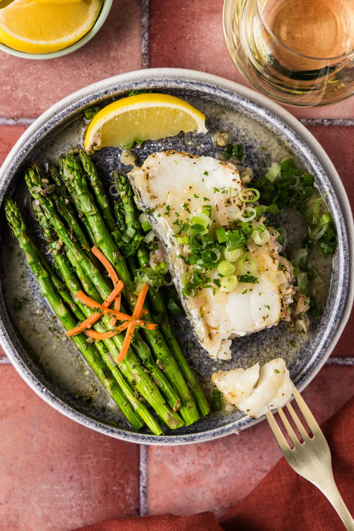 Steamed Chilean Sea Bass on a plate broken apart by a fork