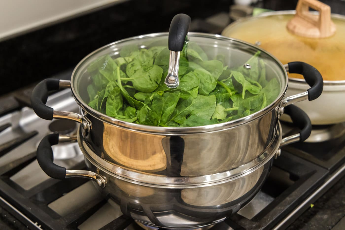 fresh spinach added to steam pot with lid