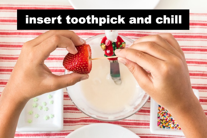 inserting toothpick into strawberry