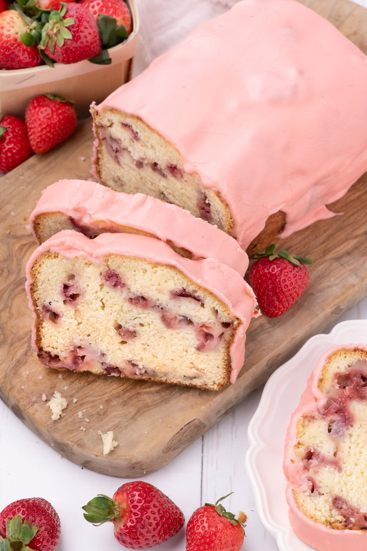 Strawberry Pound Cake on a wooden board with two slices cut