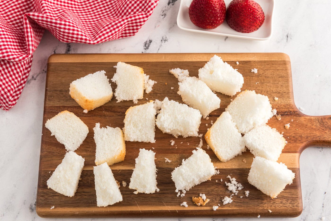 cubed angel food cake on a cutting board