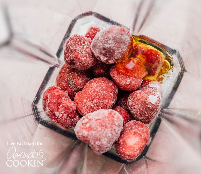frozen strawberries and honey in a blender