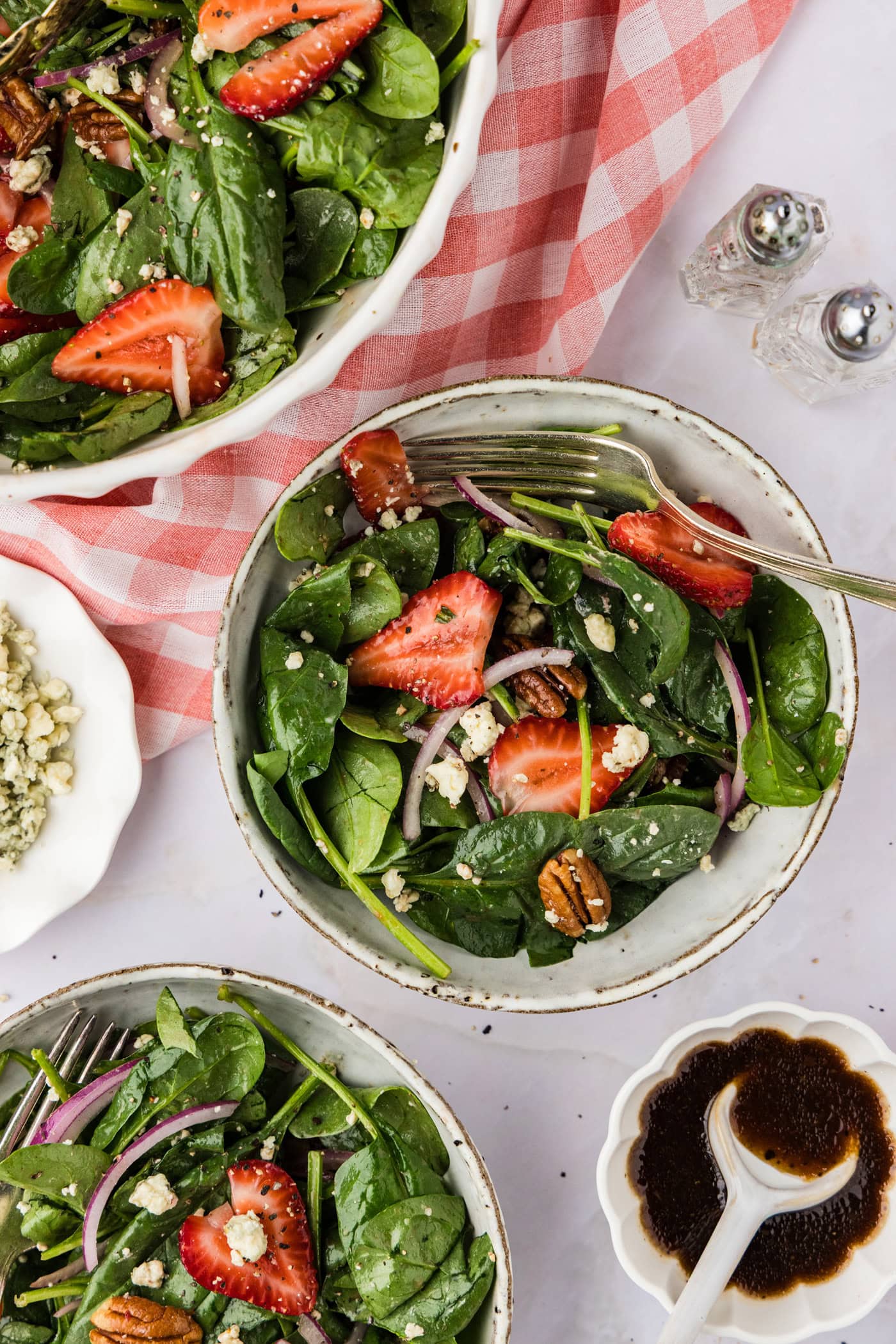 two bowls of Strawberry Spinach Salad with a pink checkered linen