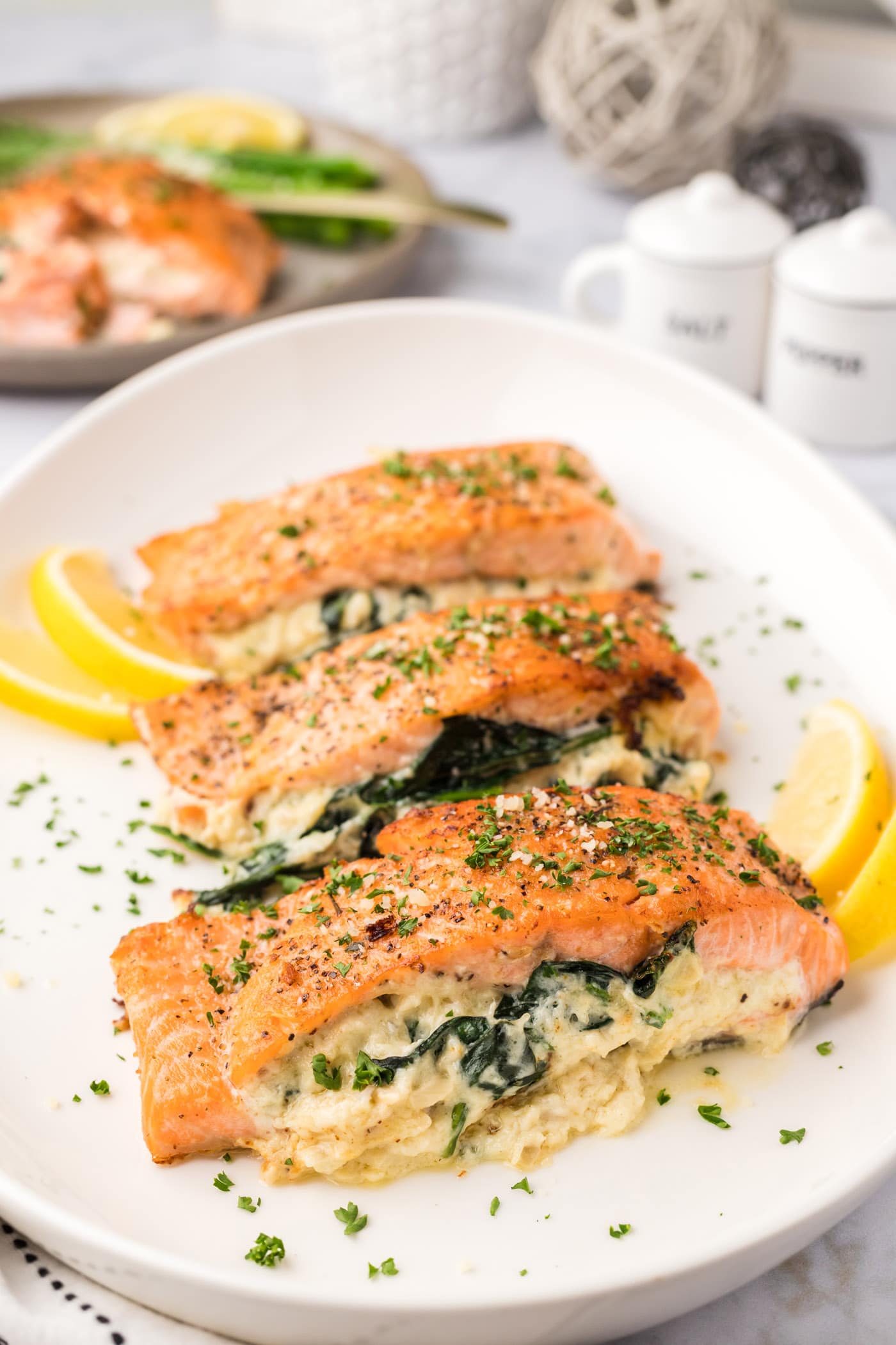 Stuffed Salmon on a white platter with lemons