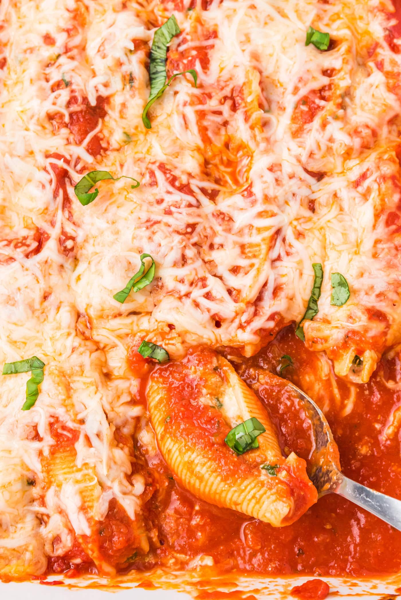 pan of Stuffed Shells with a spoon