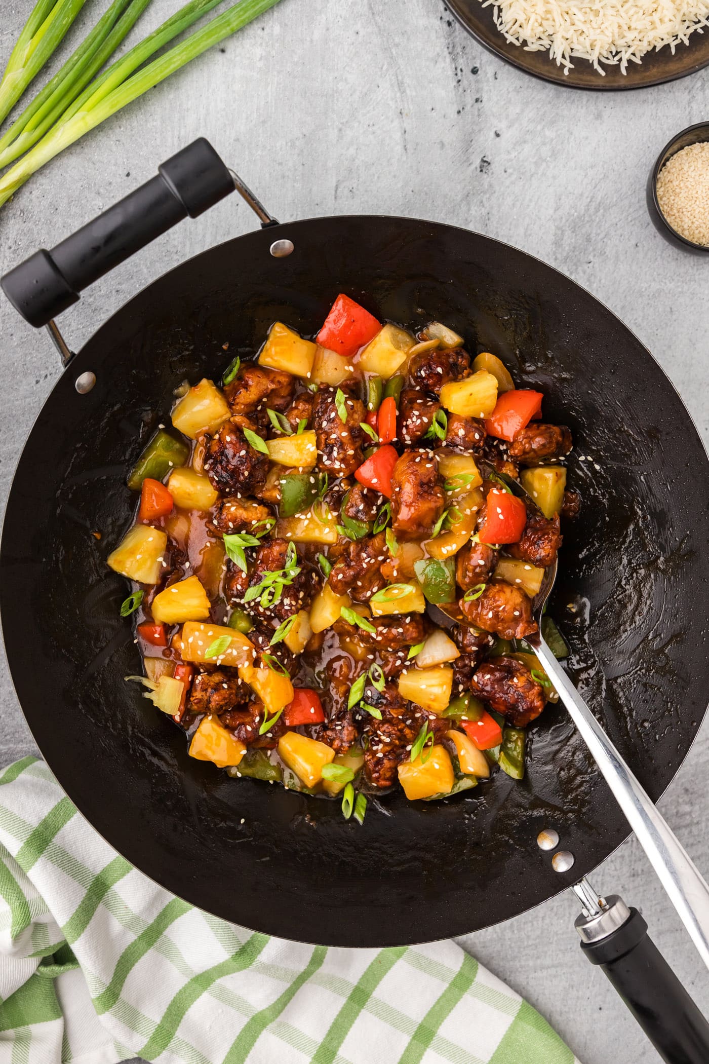Wok of Sweet and Sour Pork with a spoon in it