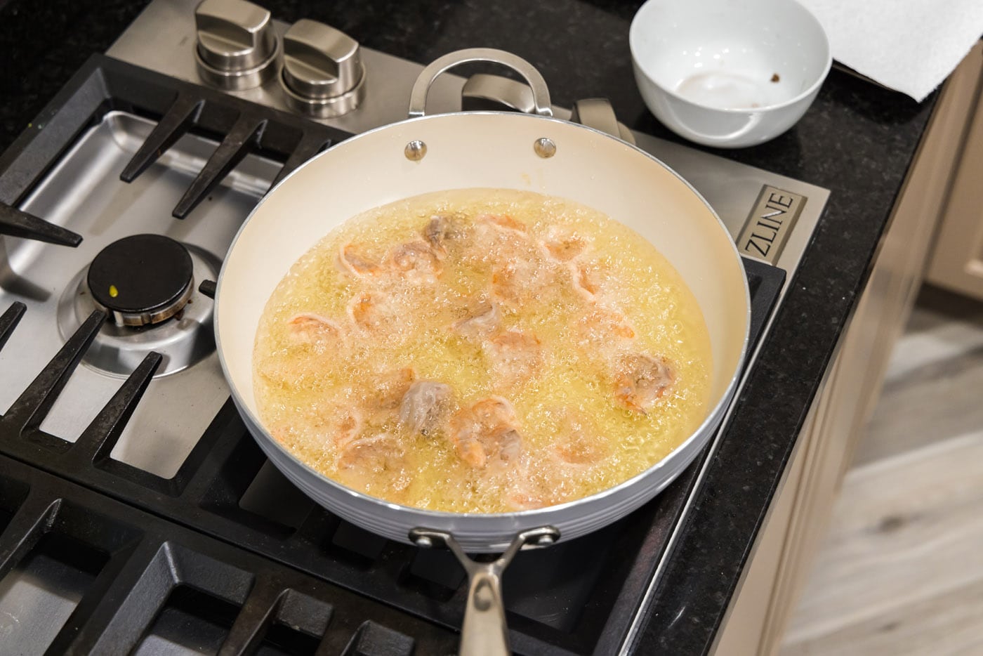 deep frying shrimp in a skillet of oil