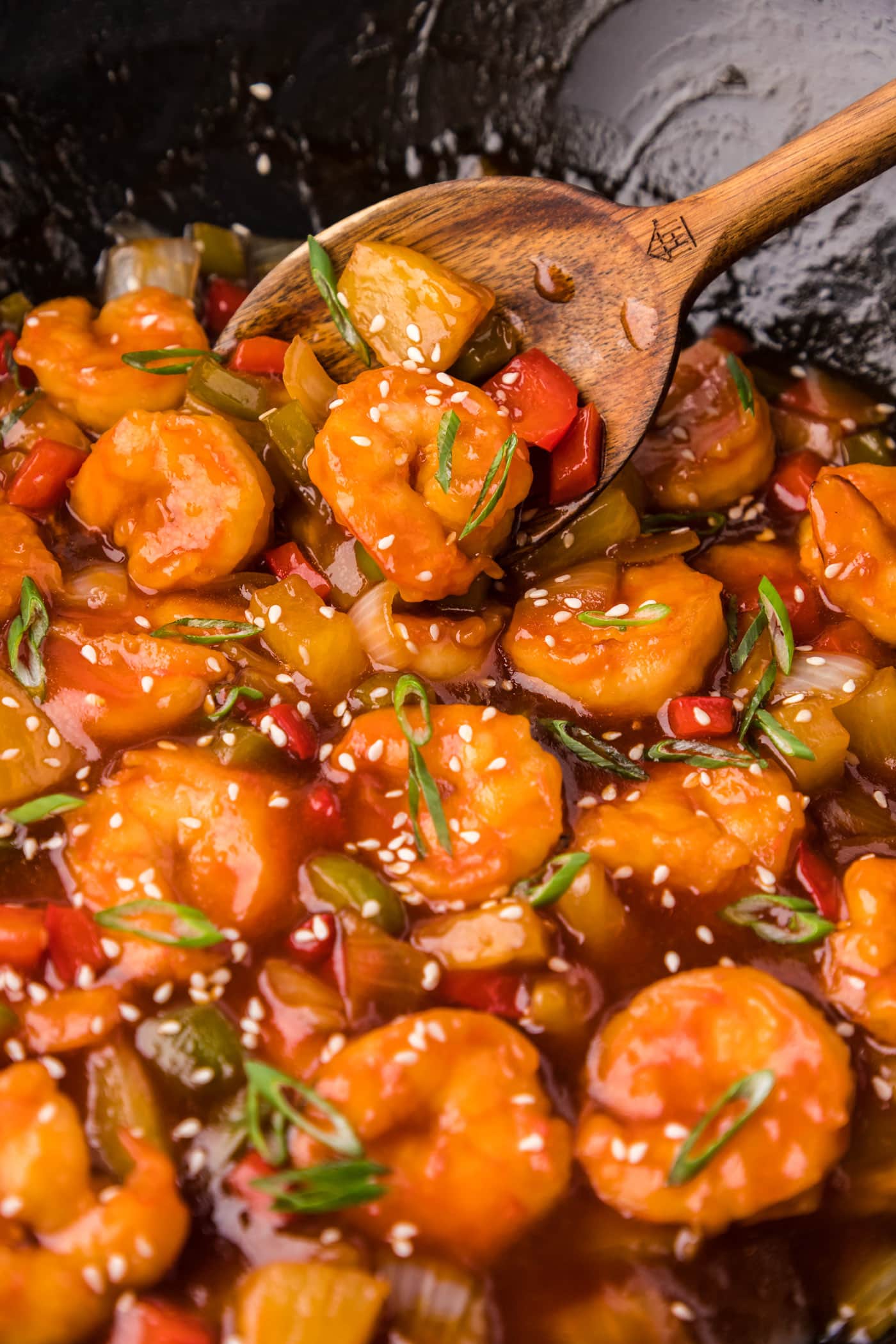 Close up photo of Sweet and Sour Shrimp in a wok with a spoon