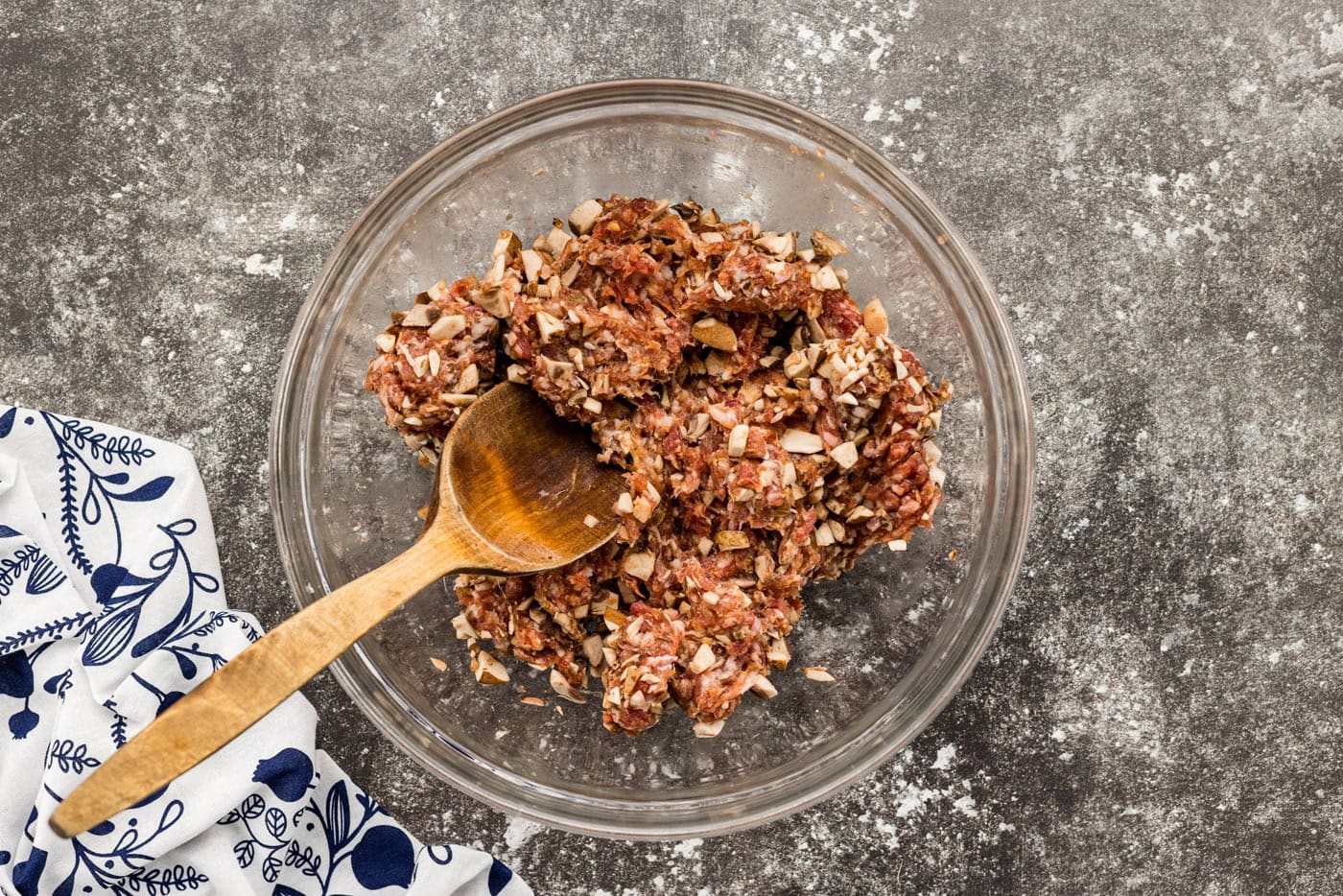 mixing sausage and mushrooms in a bowl