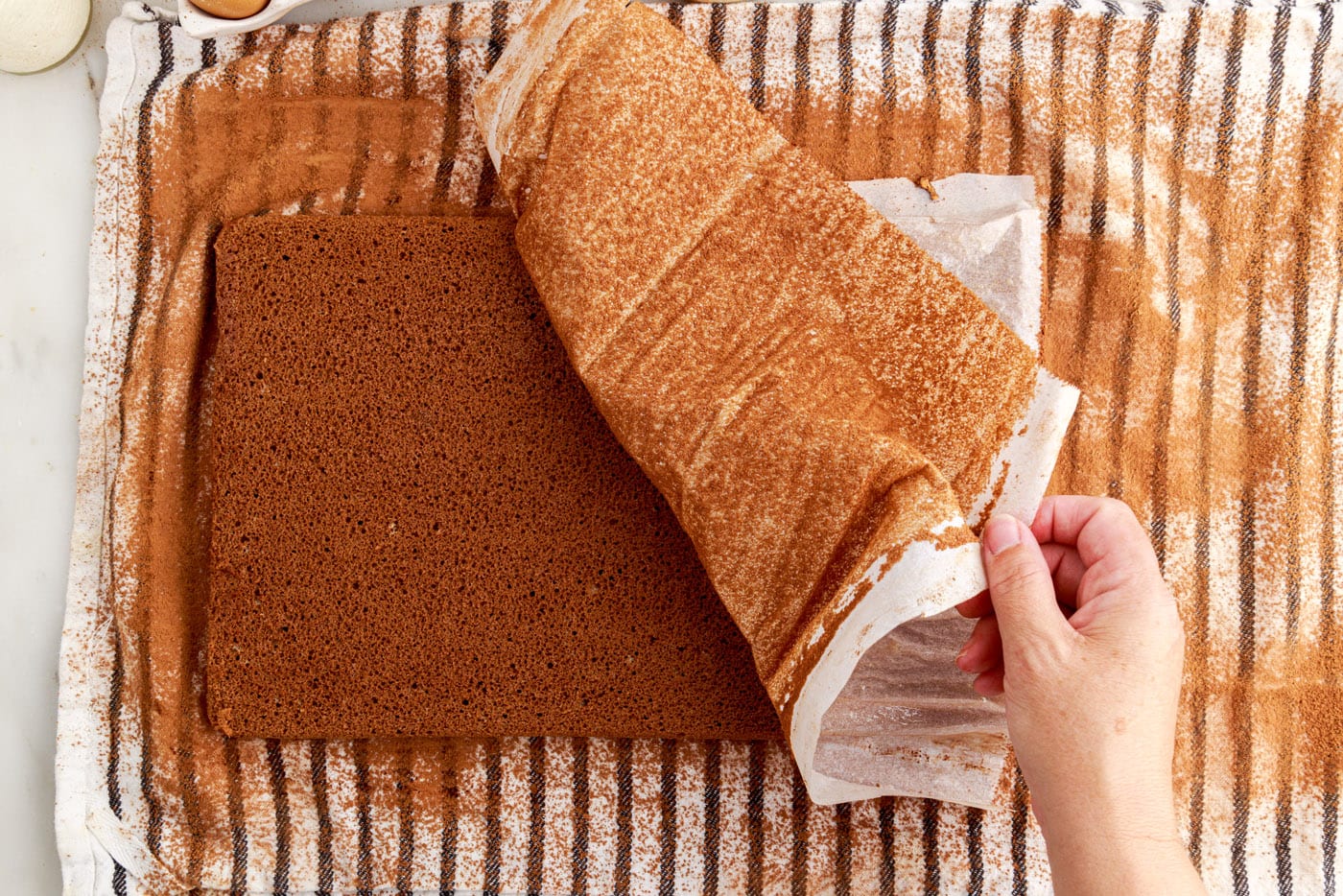 placing jelly roll cake onto towel