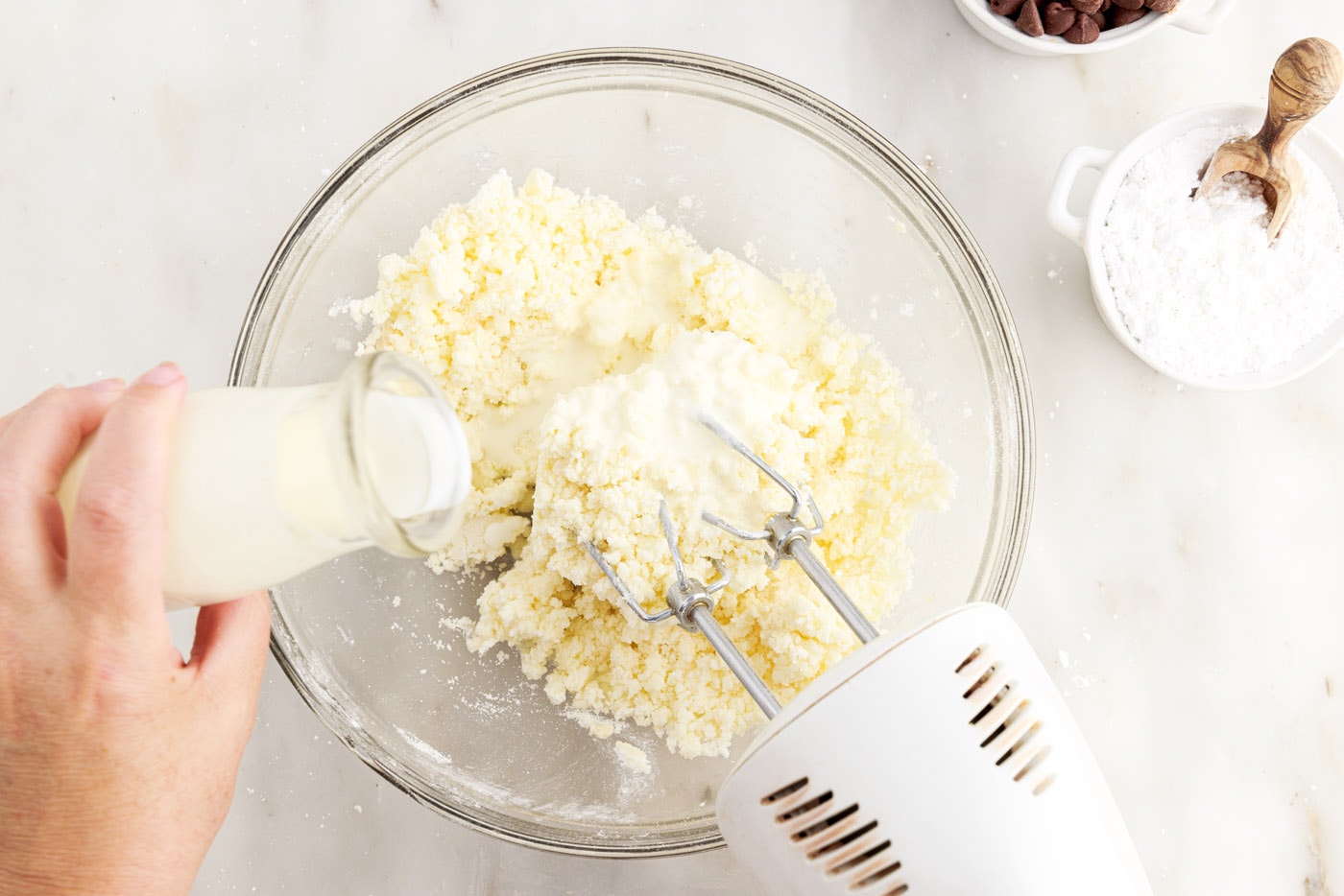 adding heavy cream to powdered sugar and butter mixture