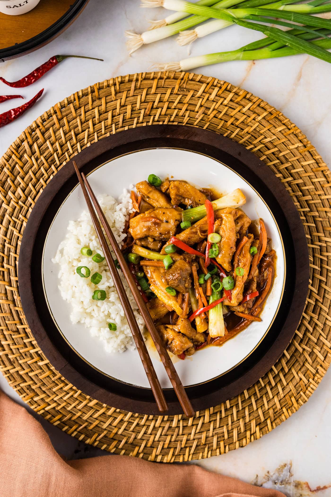 Plate of Szechuan Chicken with rice and chopsticks