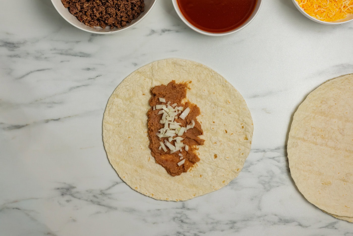 diced onion on top of refried beans