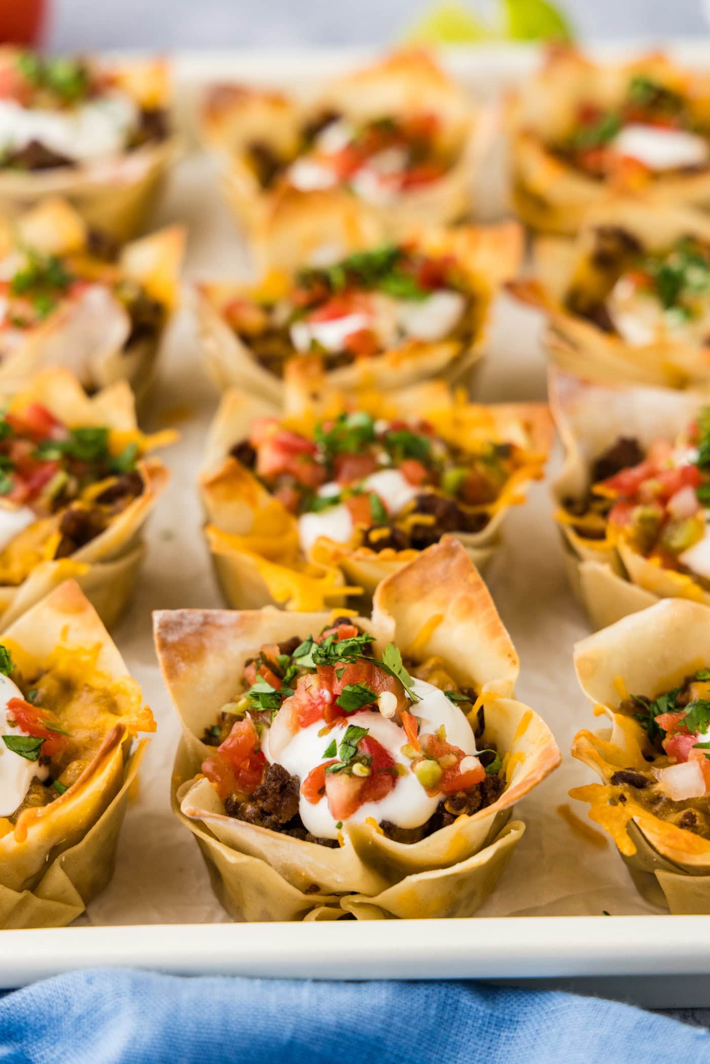 Close up photo of Taco Cups topped with sour cream and Pico de Gallo
