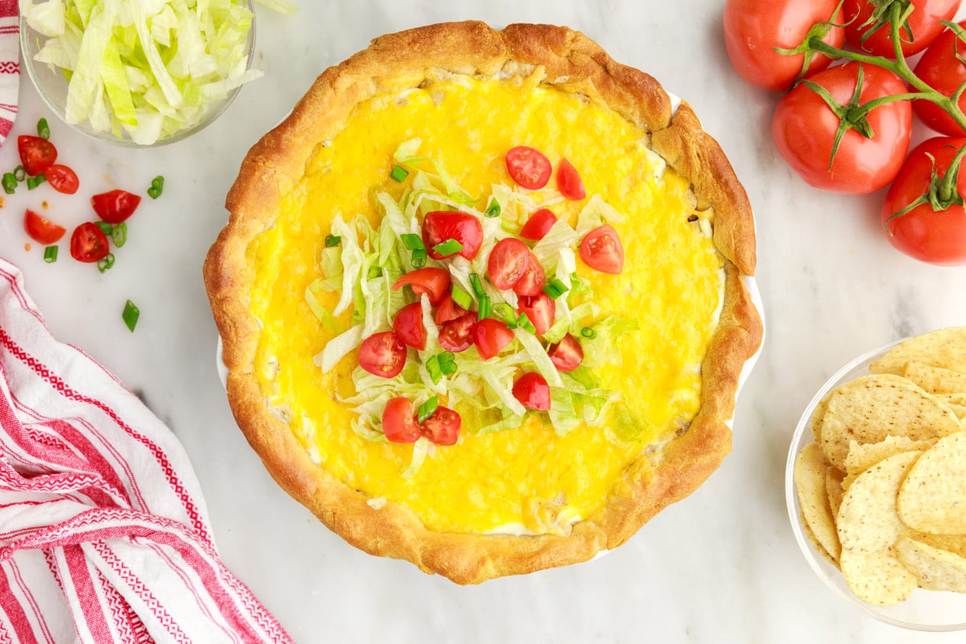 diced tomatoes and lettuce on top of taco pie