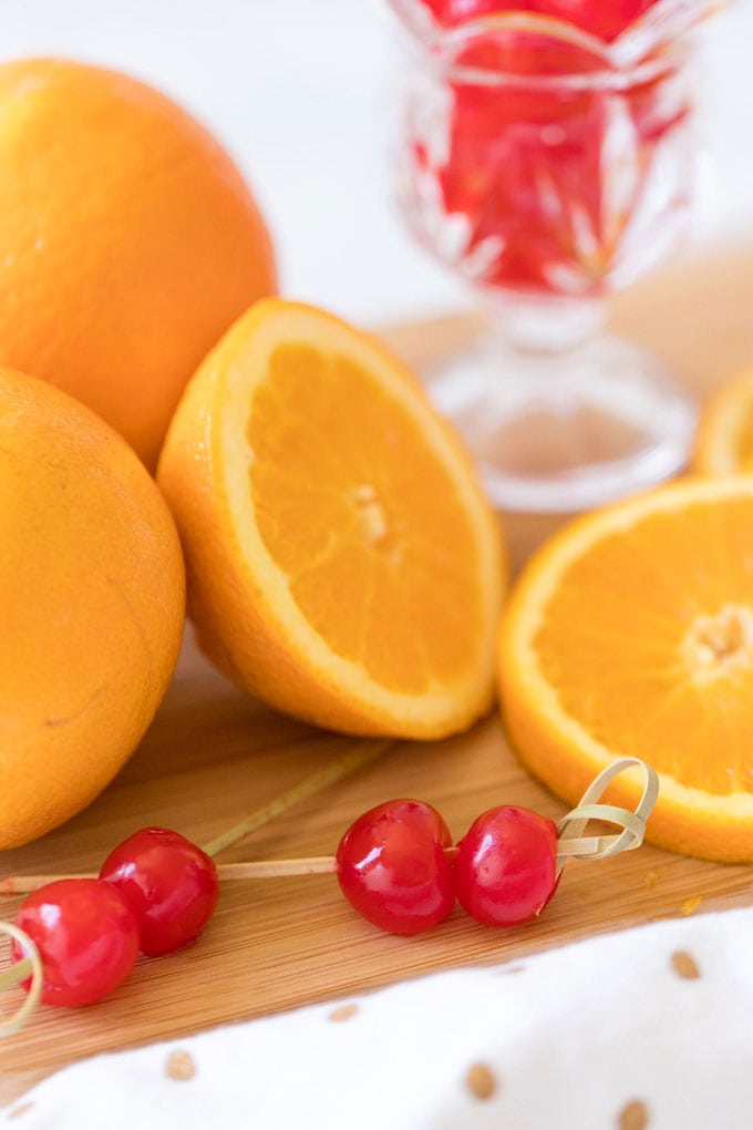 marischino cherries skewered on toothpicks with sliced oranges