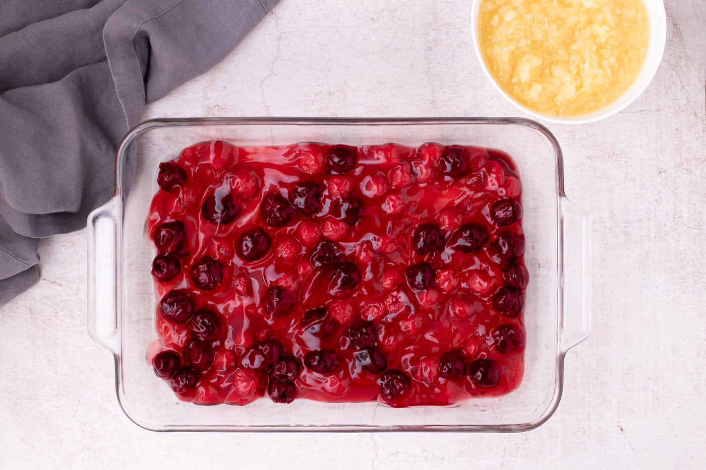pitted cherries and cherry pie filling in a baking dish