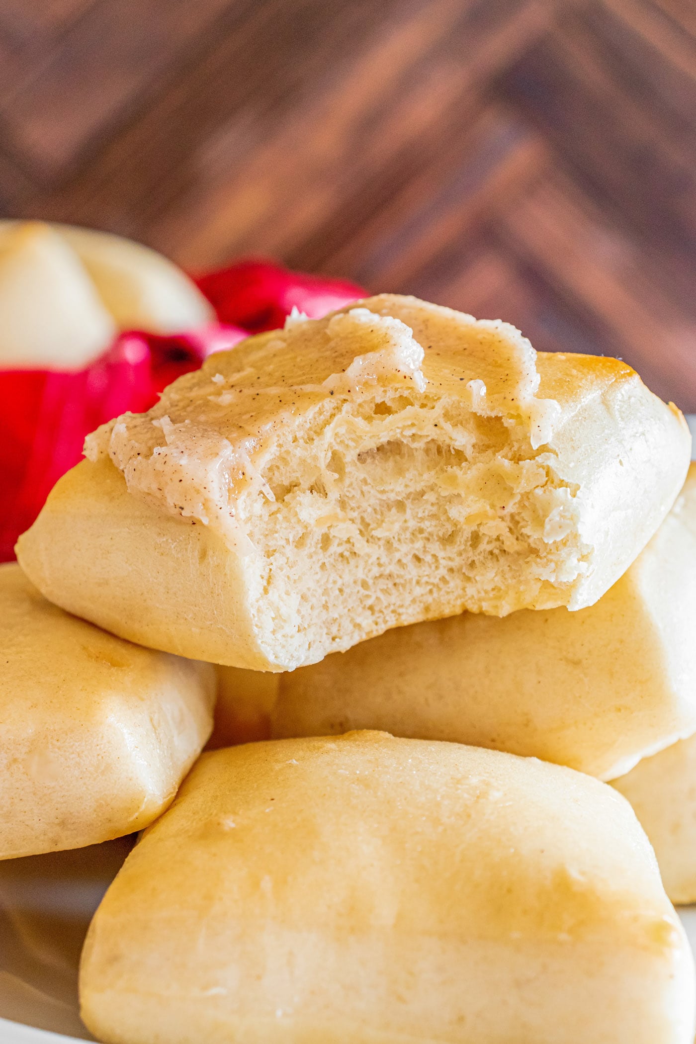 Close up photo of a Texas Roadhouse Roll topped with butter with a bite taken out