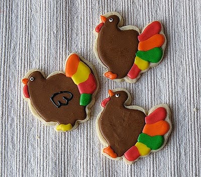 A photo of three thanksgiving turkey cookies.