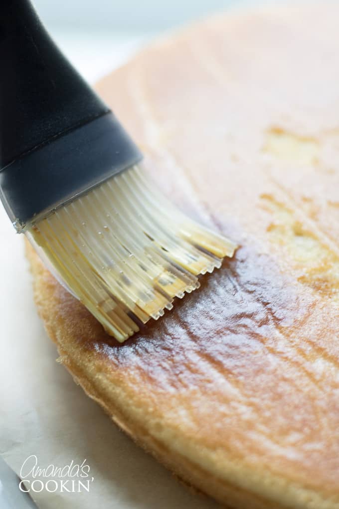 brushing espresso syrup on cake layer