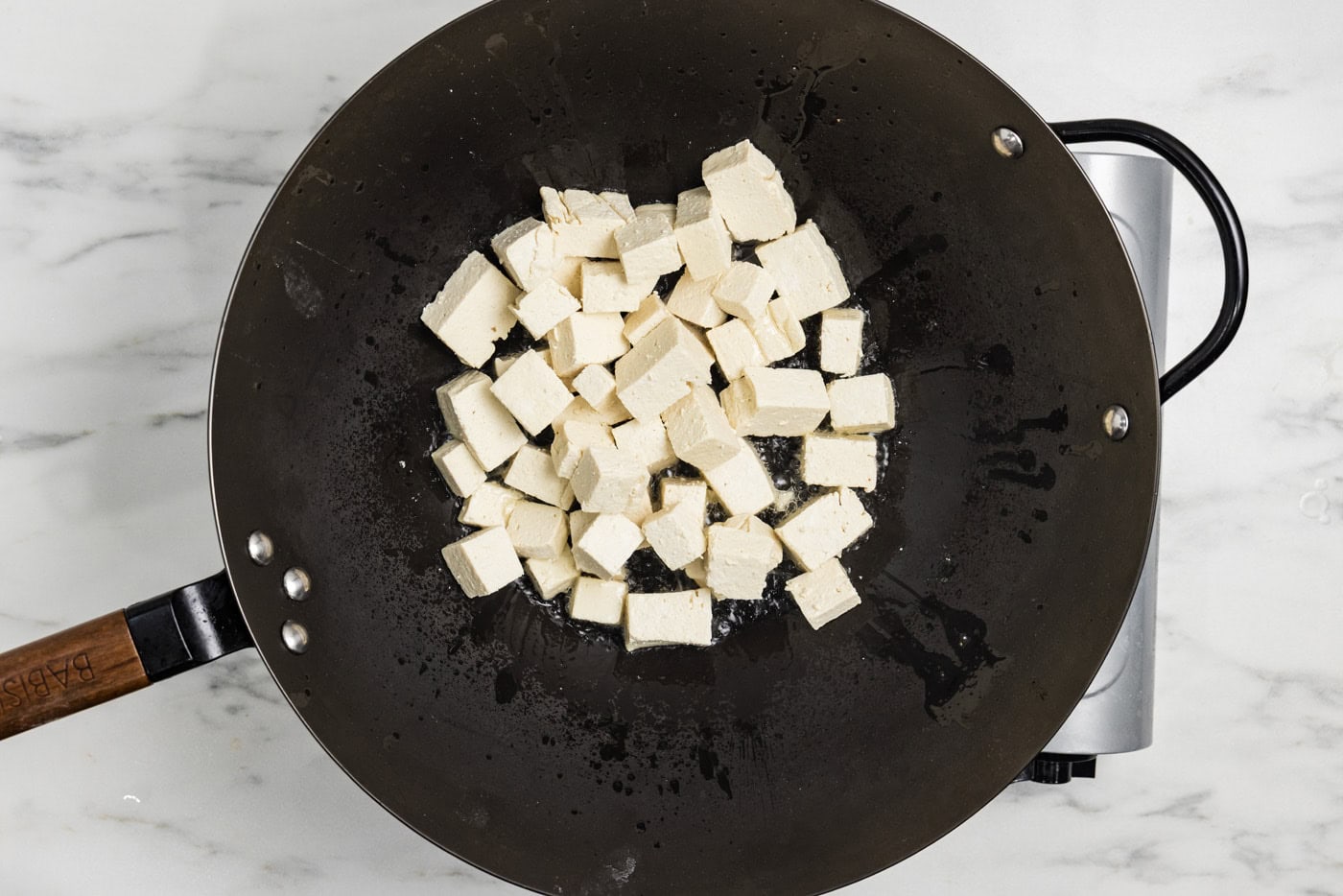 cornstarch coated tofu cubes in a wok