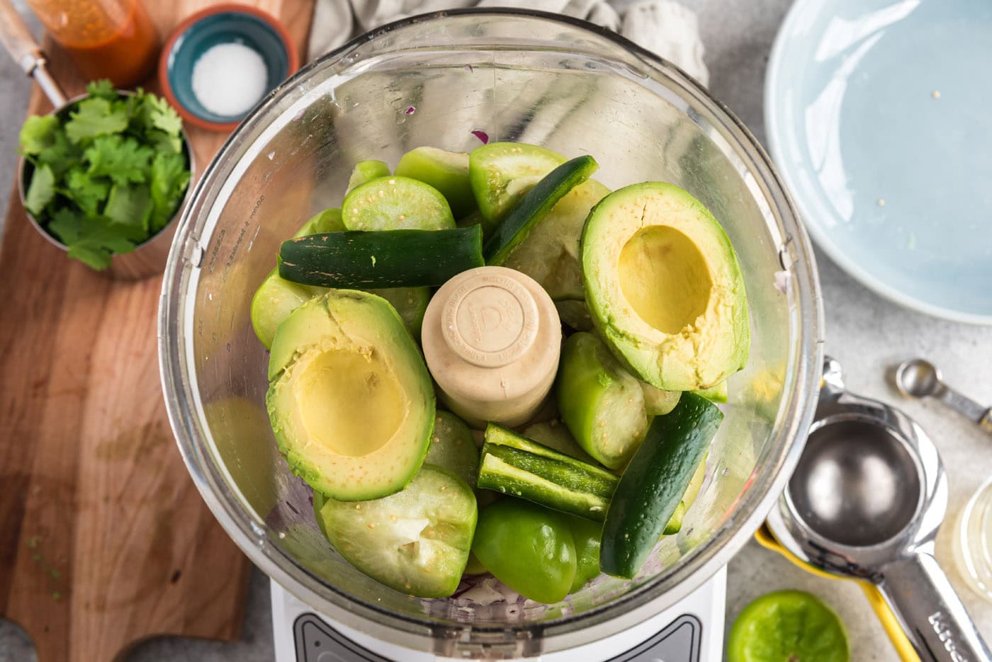 avocado and serrano chile pepper added to food processor with red onion