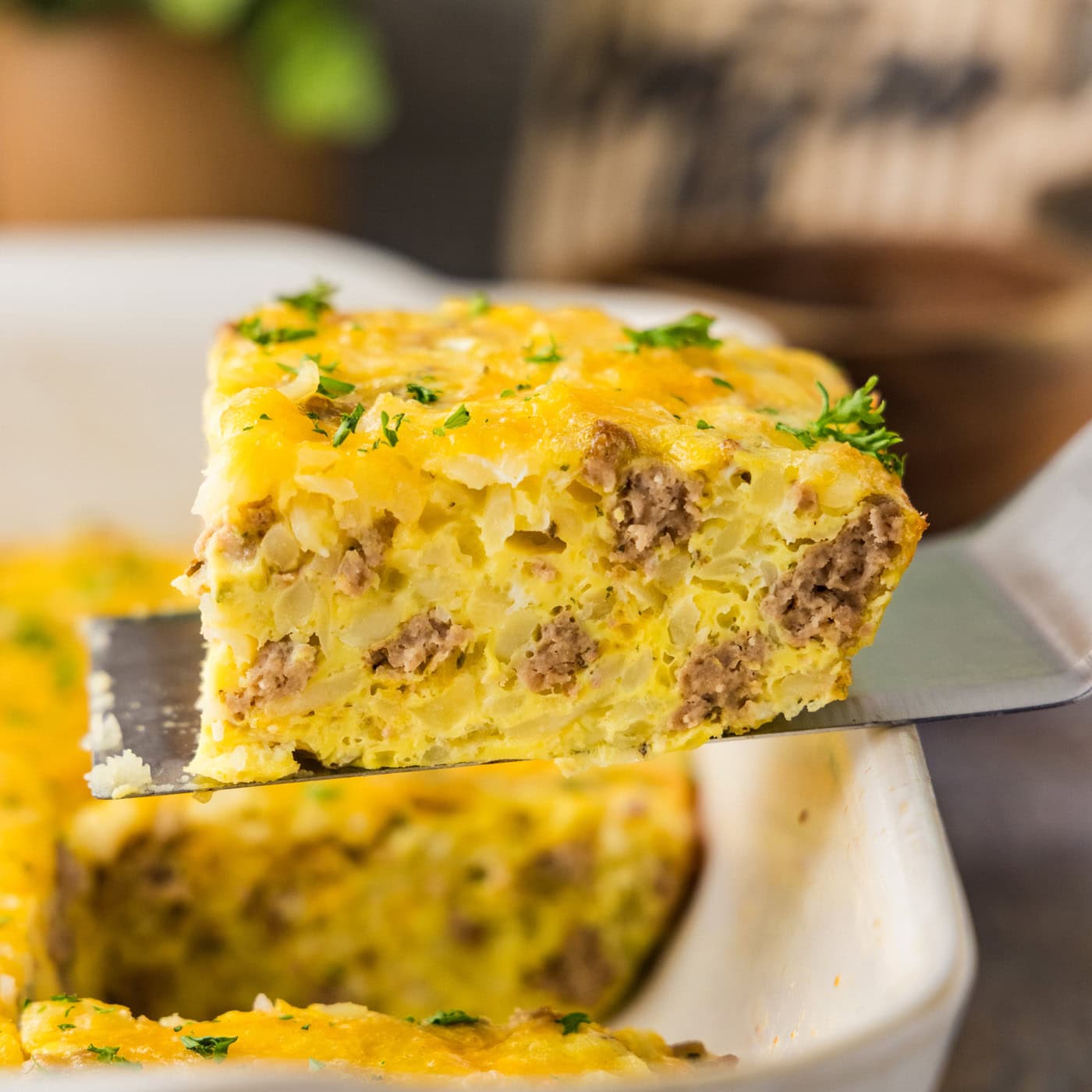A close up of a square of turkey hash brown breakfast casserole on a spatula.