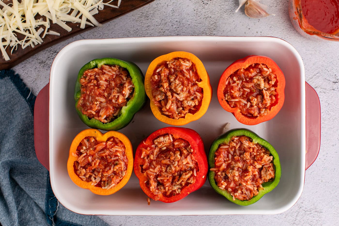 bell peppers with rice and turkey filling in a casserole dish