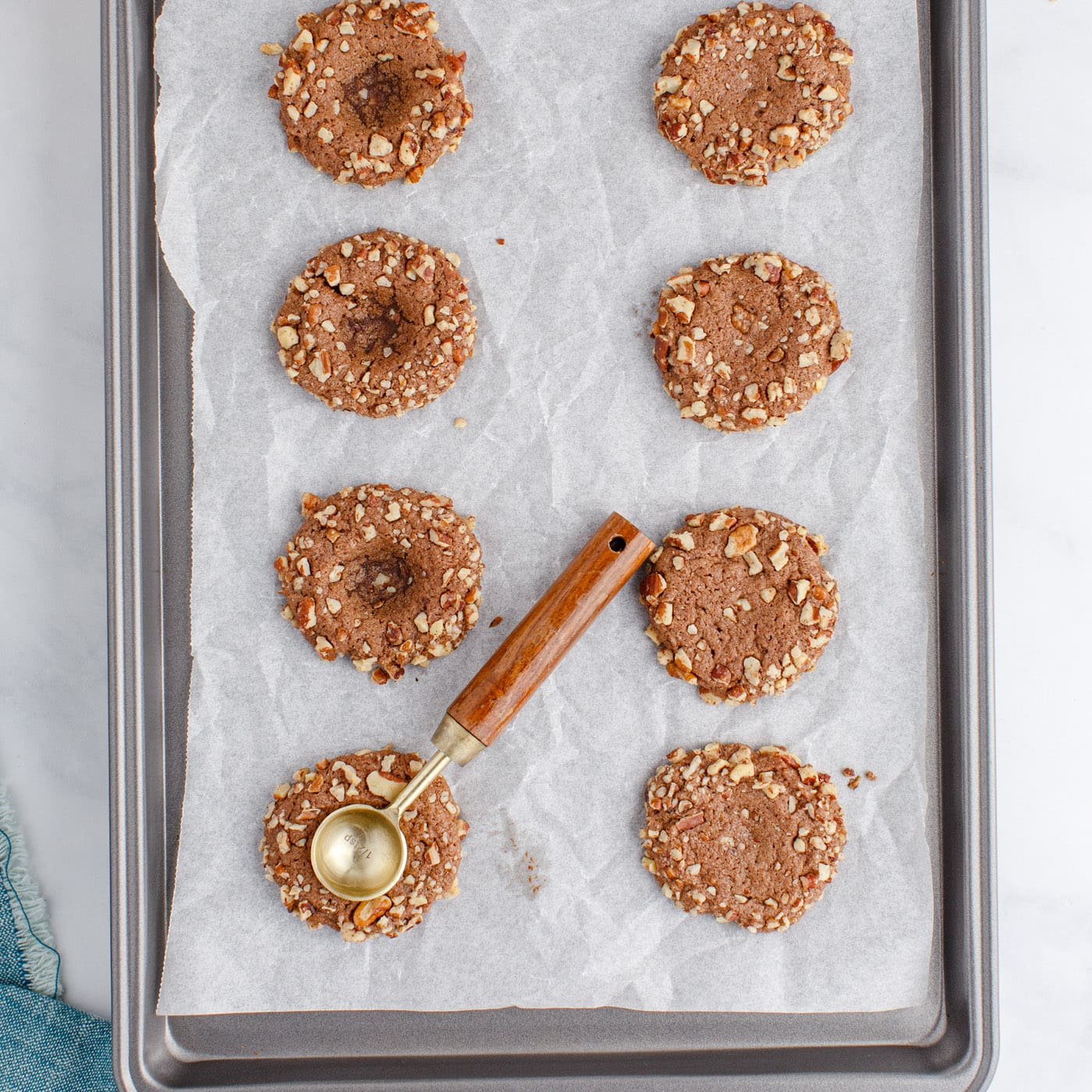 measuring spoon creating indents in thumbprint cookies