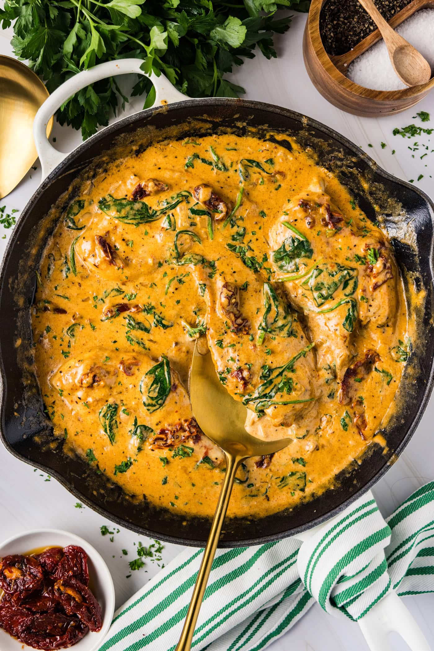 Skillet of Tuscan Chicken with a spatula in it