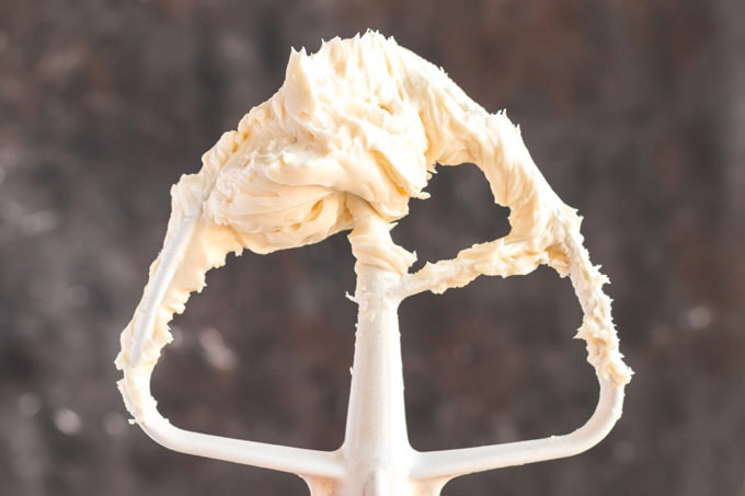 stand mixer paddle attachment covered in cream cheese mixture
