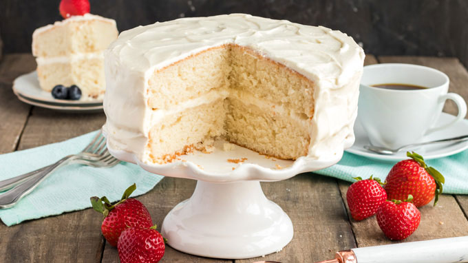 white cake with two slices removed sitting on a cake plate