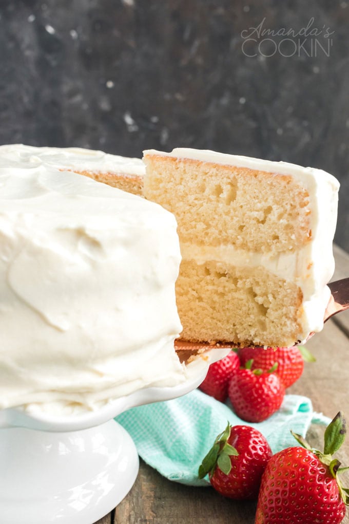 removing a slice of white cake from platter
