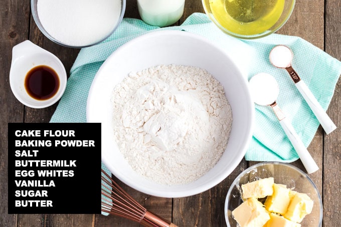 labeled ingredients for white cake recipe: cake flour, baking powder, salt, buttermilk, egg whites, vanilla, sugar, butter