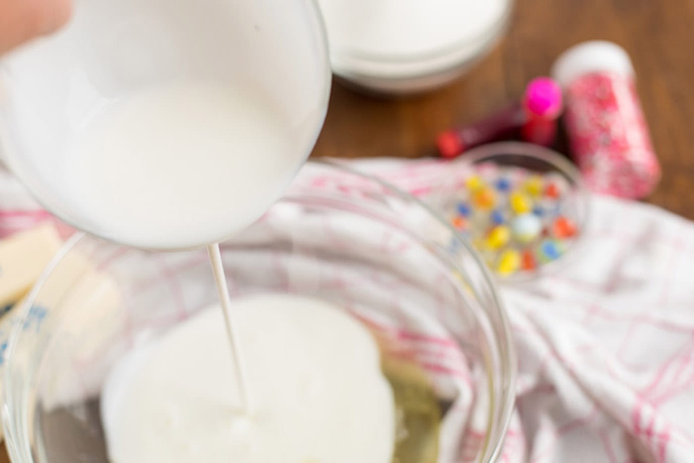 Buttermilk being poured into a bowl of egg whites