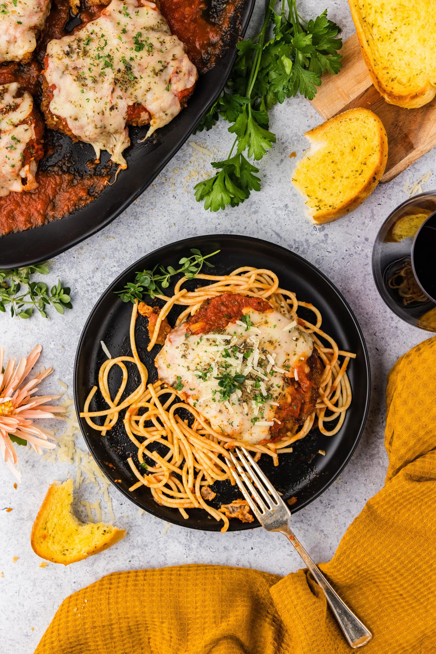 Plate of Veal Parmesan with garlic bread to the side
