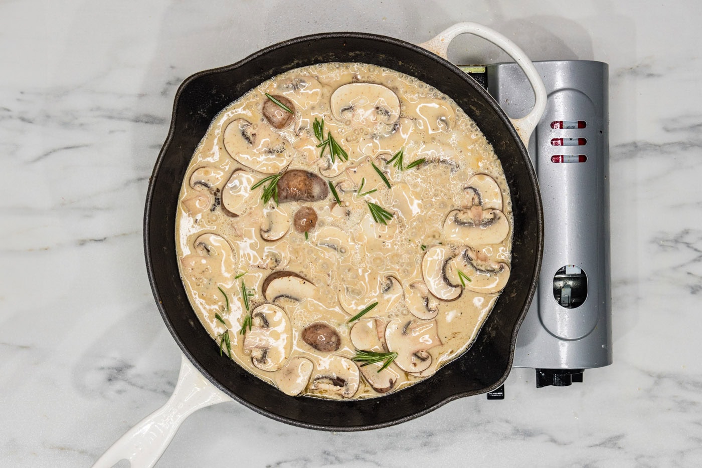creamy scallopini sauce in a skillet with mushrooms