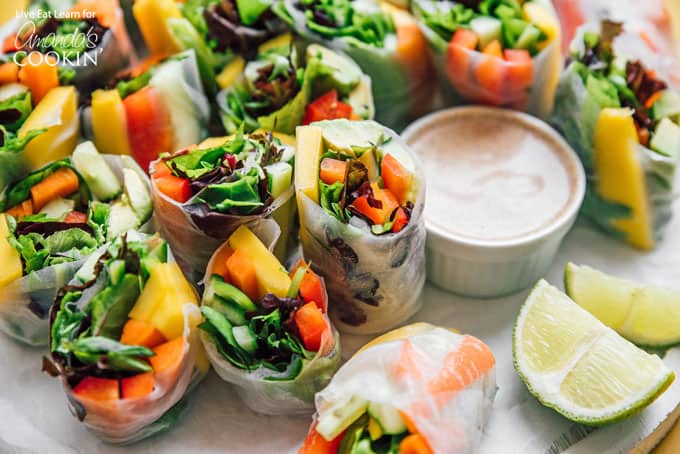 Vegetable spring rolls with dipping sauce and lime wedges