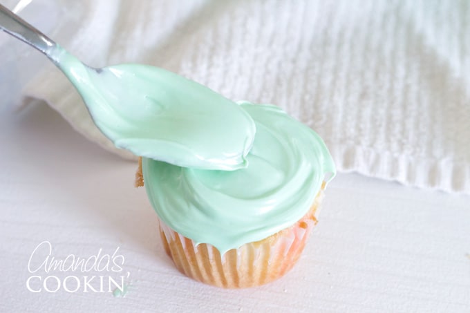 spreading cupcake with frosting