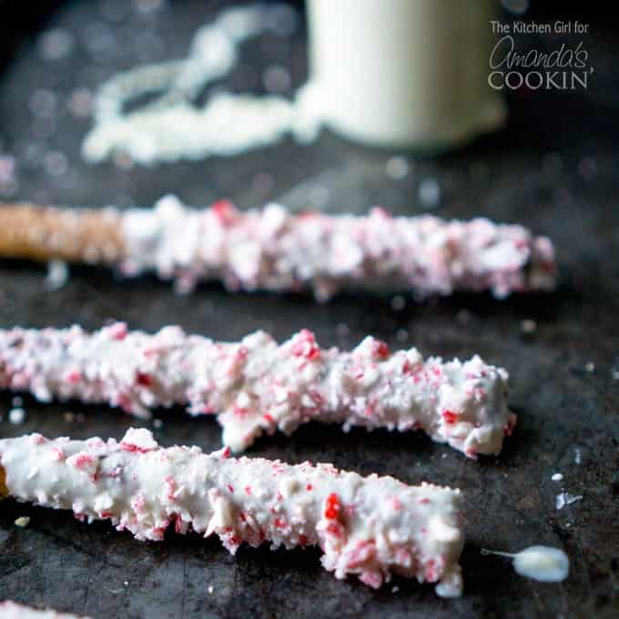 A close up photo of three white chocolate candy cane pretzel sticks.