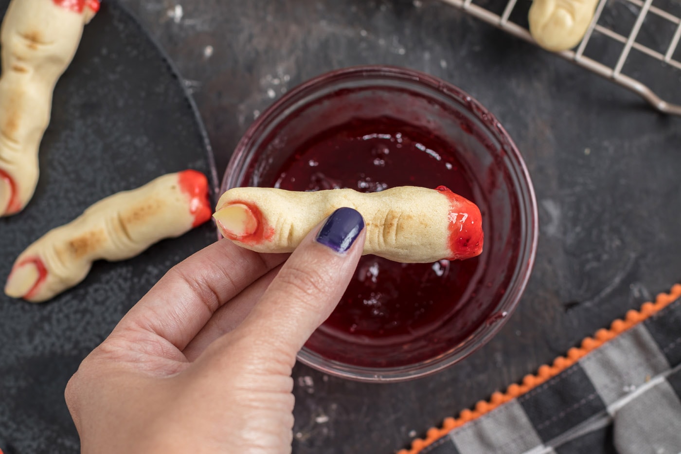 dipping witch finger cookies in jam