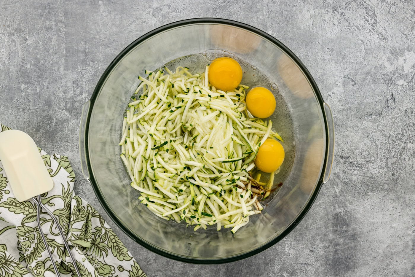 shredded zucchini, eggs, oil, and vanilla in a mixing bowl