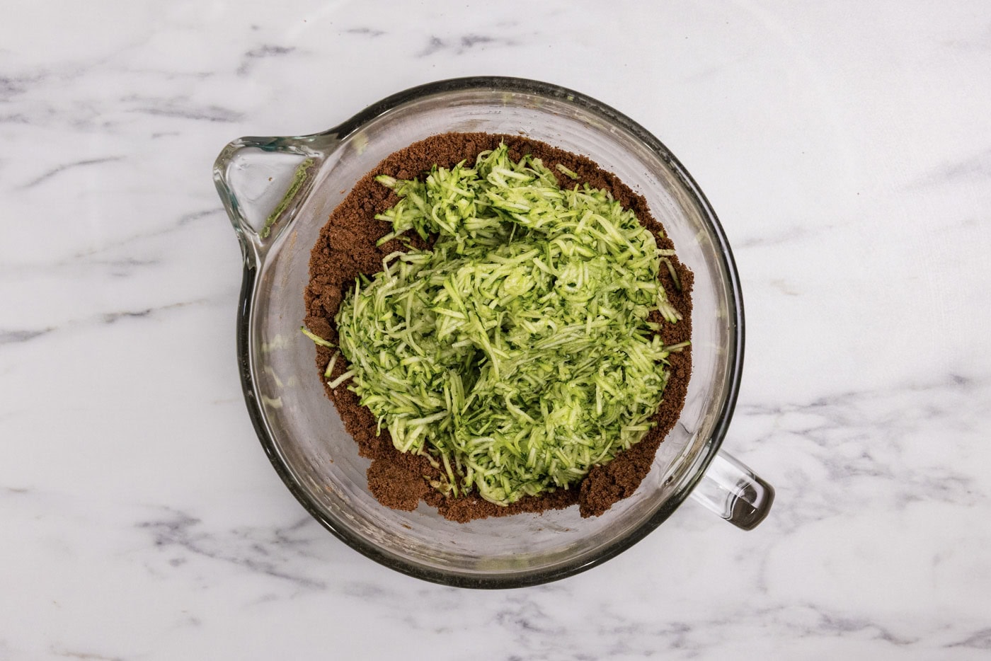 shredded zucchini added to bowl with brownie mixture