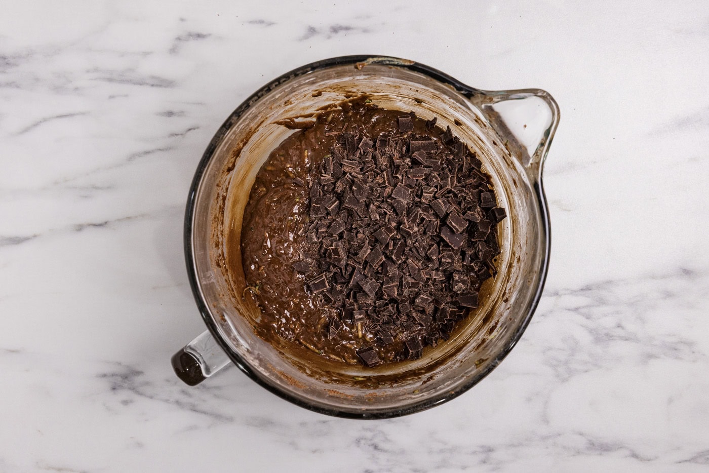 chopped chocolate added to bowl with brownie batter