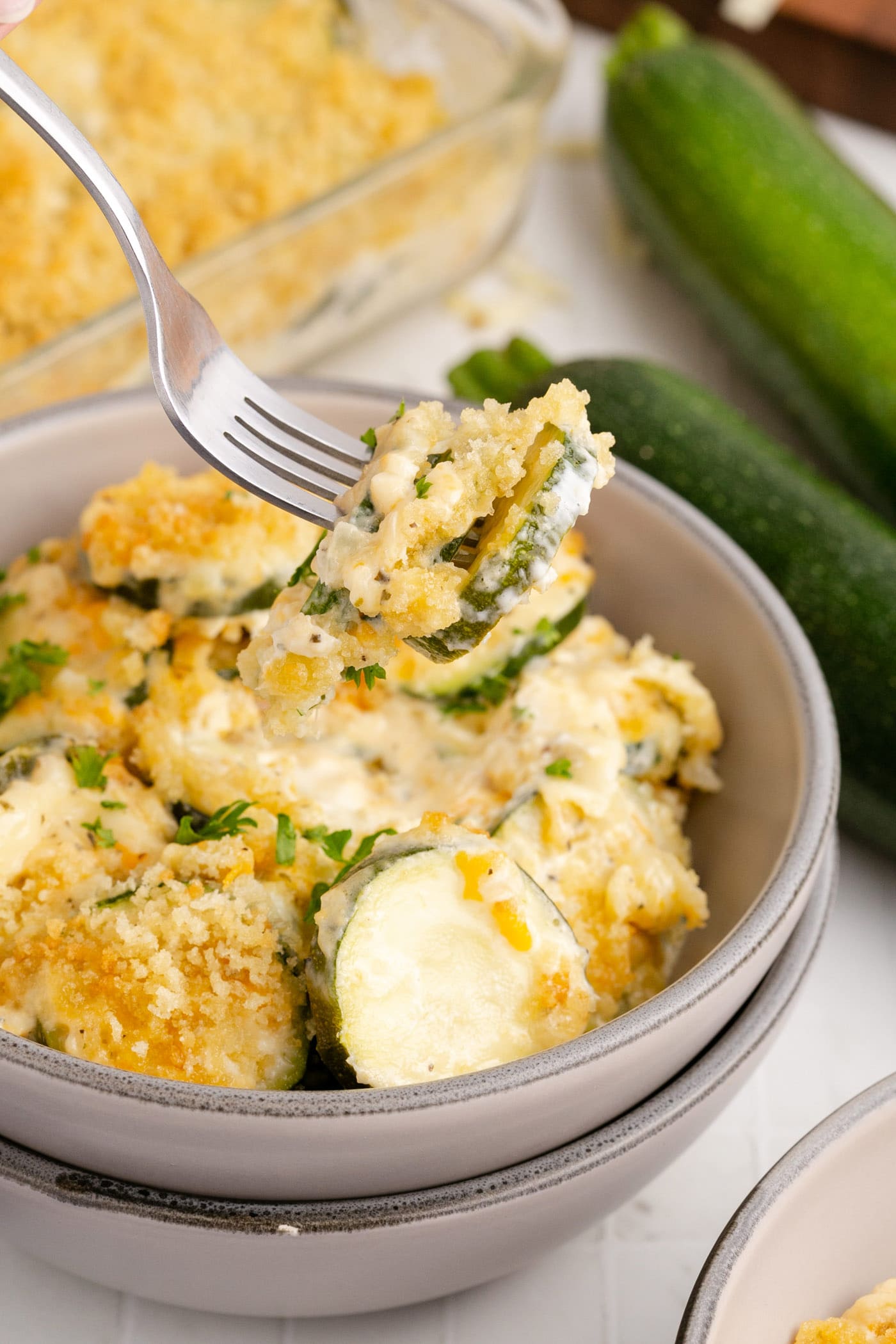 Zucchini Casserole on a fork being lifted out of a bowl of Zucchini Casserole