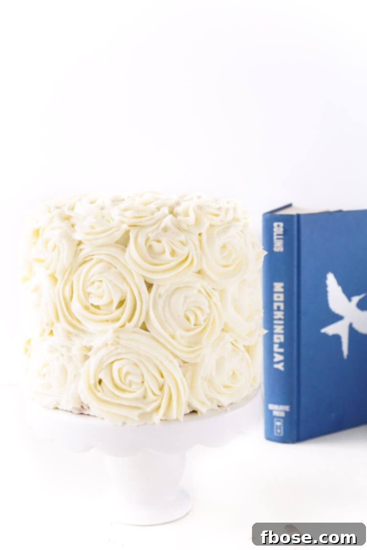 Decadent Red Velvet Cake with pristine white cream cheese frosting, inspired by President Snow's White Roses from The Hunger Games, a perfect dessert for Valentine's Day celebrations.